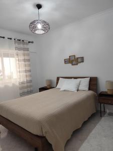 a bedroom with a large bed and a light at BEACH house in Sesimbra +14 photos
