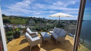 a patio with chairs and an umbrella on a balcony at Valley View Haven in Kingsbridge