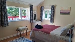 a bedroom with a bed and two windows at Valley View Haven in Kingsbridge