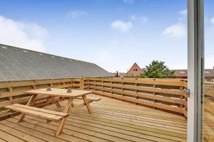 a wooden deck with a wooden table and a bench at Activity House With Wellness Area-Sj700 in Thyborøn