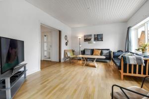 a living room with a couch and a table at Activity House With Wellness Area-Sj700 in Thyborøn