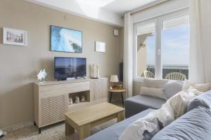a living room with a couch and a tv at Abaco in Playa de Xeraco