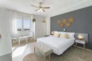 a bedroom with a white bed and a ceiling fan at Abaco in Playa de Xeraco
