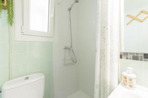 a bathroom with a toilet and a shower with a window at Abaco in Playa de Xeraco +21 photos