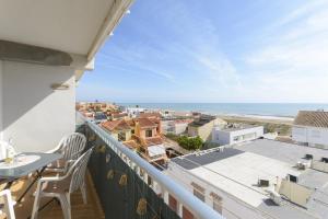 a balcony with a table and chairs and a view of the ocean at Abaco in Playa de Xeraco