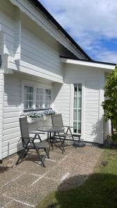 a table and chairs in front of a house at Mysig stuga Östra stranden in Halmstad