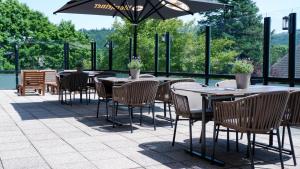 a patio with tables and chairs and an umbrella at Der Wolfshof - Dein Zuhause im Harz in Langelsheim
