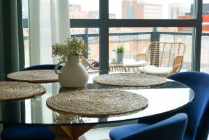 a table with chairs and a vase on top at Stylish 2-Bed Apartment, Free Parking, Walk to Hospital & Uni in Sheffield