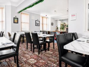 a dining room with a table and black chairs at Highfield Hotel Blackpool in Blackpool
