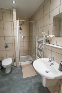 a bathroom with a toilet and a sink and a shower at Stylish 2-Bed Apartment, Free Parking, Walk to Hospital & Uni in Sheffield +38 photos