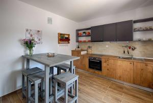 a kitchen with wooden cabinets and a table with stools at Luxury Beachfront Villa Kata in Rogotin