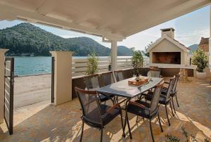 a patio with a table and chairs and a fireplace at Luxury Beachfront Villa Kata in Rogotin