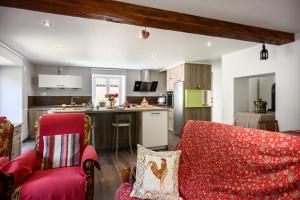 a living room with a red couch and a kitchen at Gite Les Jonquilles in Mittlach