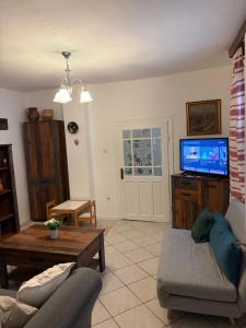 a living room with a couch and a tv at Árpád nyaralóház in Sarud