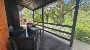 a screened in porch with chairs and a table at ČANJ Apartman Slavica in Čanj
