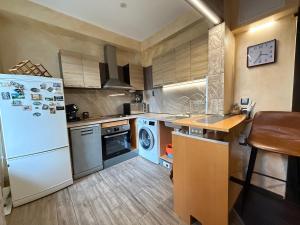 a kitchen with a white refrigerator and a dishwasher at Етаж от къща в Разград in Razgrad