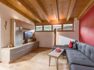 a living room with a blue couch and a tv at Ferienwohnung Schwarzenauer in Fügen