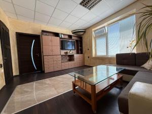 a living room with a couch and a glass table at Етаж от къща в Разград in Razgrad +4 photos