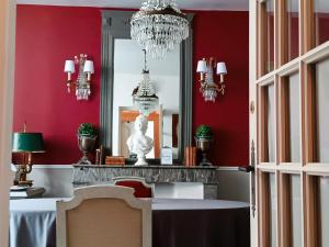 a dining room with red walls and a chandelier at Maison Nº 20 in Eymet