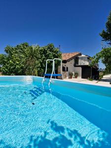a blue swimming pool with a swing in the water at La Dolce Vita in Castelfidardo