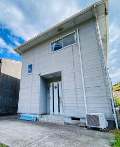 ein großes weißes Gebäude mit einer großen Tür in der Unterkunft Guest House 楽風 in Anan