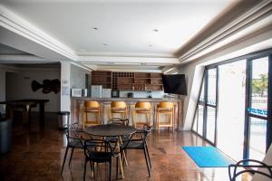a room with a table and chairs and a kitchen at Praia Hotel Enseada in Maceió