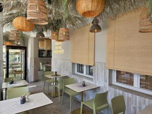 a restaurant with tables and chairs and windows at Ruchome Piaski in Łeba