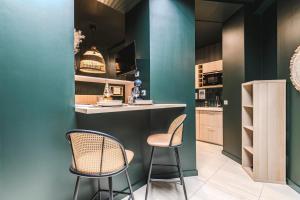 two chairs and a bar in a kitchen with green walls at SPA Balnéo des Sacres-REIMS-Centre Ville in Reims