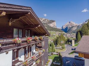 a house with flowerpots on the balcony with a mountain at Garni Tramans in Selva di Val Gardena