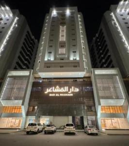 two tall buildings with cars parked in front of them at شقه دار المشاعر فى دار الاركان لشقق لاكجرى in Mecca