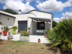 a white house with a patio with a table at Océane in Saint-Augustin