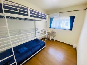 ein Schlafzimmer mit zwei Etagenbetten in einem Zimmer in der Unterkunft Guest House 楽風 in Anan
