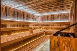 a sauna with wooden walls and a wooden tub at Hotel Alpenstolz - Culinary Hideaway Stubai in Mieders