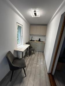 eine kleine Küche mit einem Tisch und einem Stuhl in der Unterkunft Apart Robert 2 in Bicaz