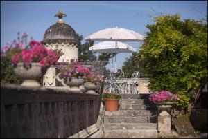a stairway with potted flowers and a building with an umbrella at CHATEAU DE LA RIVIERE in La Rivière