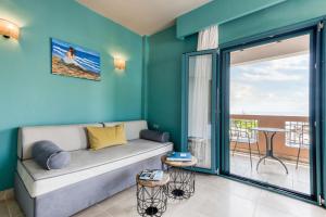 a living room with a couch and a balcony at Armeno Resort in Marathias