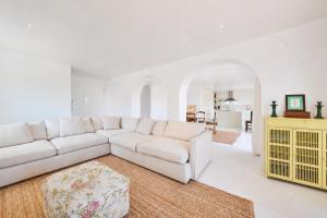 a living room with a white couch and a yellow cabinet at Casa Branca - Caparica in Charneca
