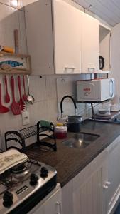 a kitchen counter with a stove and a sink at L&S casa da lagoa in Búzios