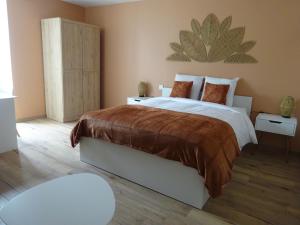 a bedroom with a large bed with a large plant on the wall at Les Précieuses in Réaumur