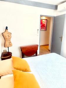 a bedroom with a bed with yellow sheets and a desk at Entre Pic et Rivière in Saint-Martin-de-Londres