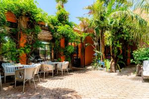an outdoor patio with tables and chairs and plants at Hotel Madreselva - Grupo Califa in Los Caños de Meca