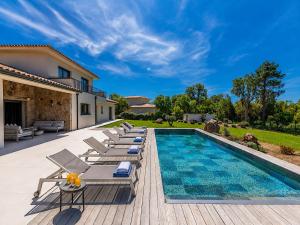 a villa with a swimming pool and lounge chairs at Villa Déoni in Zonza