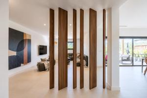 a living room with a wall of wooden dividers at Villa Déoni in Zonza