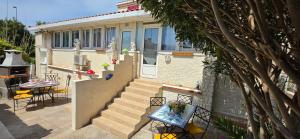 a house with a staircase and a table with chairs at Villa Jamgers in Martigues