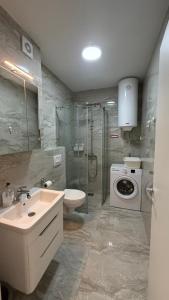 ein Badezimmer mit Waschbecken und Waschmaschine in der Unterkunft Petrus in Rafailovici + 43 Fotos