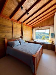 a bedroom with a bed in a room with a window at Chalé Pazinato in Venda Nova do Imigrante