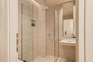a glass shower in a bathroom with a sink at MAHA Her City Living by Semavί in Heraklio +86 photos