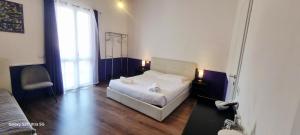 a bedroom with a white bed and a large window at Eva Luxury Saint Remy in Cagliari