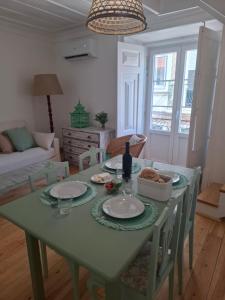 a living room with a green table with plates on it at FONTE NOVA Setubal in Setúbal