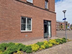 a brick building with a window and a street light at De Oude Brandweerkazerne 2 tot 4 persoons 2 kamer appartement in Kaatsheuvel